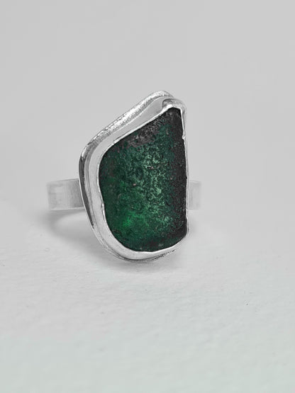 This deep emerald sea gem reveals many shades of green in different lights. It is cradled in a sterling silver bezel set upon a thick band. Made with sustainability in mind this handmade silver ring is made from 100% recycled silver.