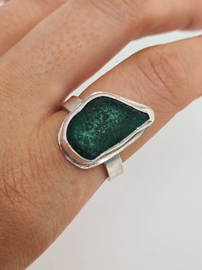 This deep emerald sea gem reveals many shades of green in different lights. It is cradled in a sterling silver bezel set upon a thick band. Made with sustainability in mind this handmade silver ring is made from 100% recycled silver.