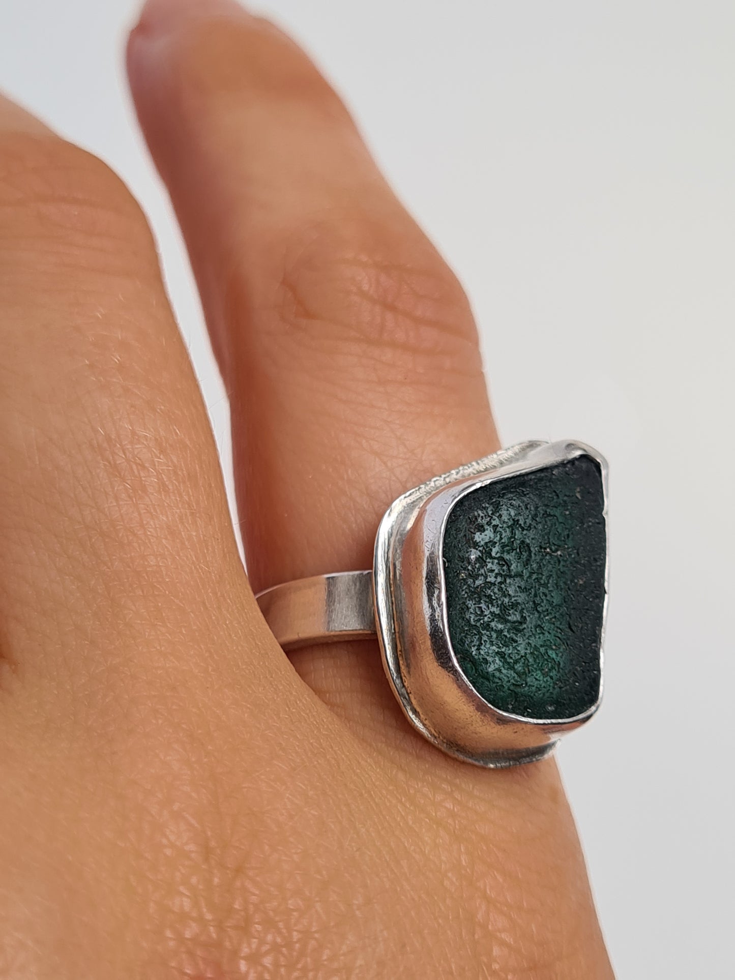 This deep emerald sea gem reveals many shades of green in different lights. It is cradled in a sterling silver bezel set upon a thick band. Made with sustainability in mind this handmade silver ring is made from 100% recycled silver.