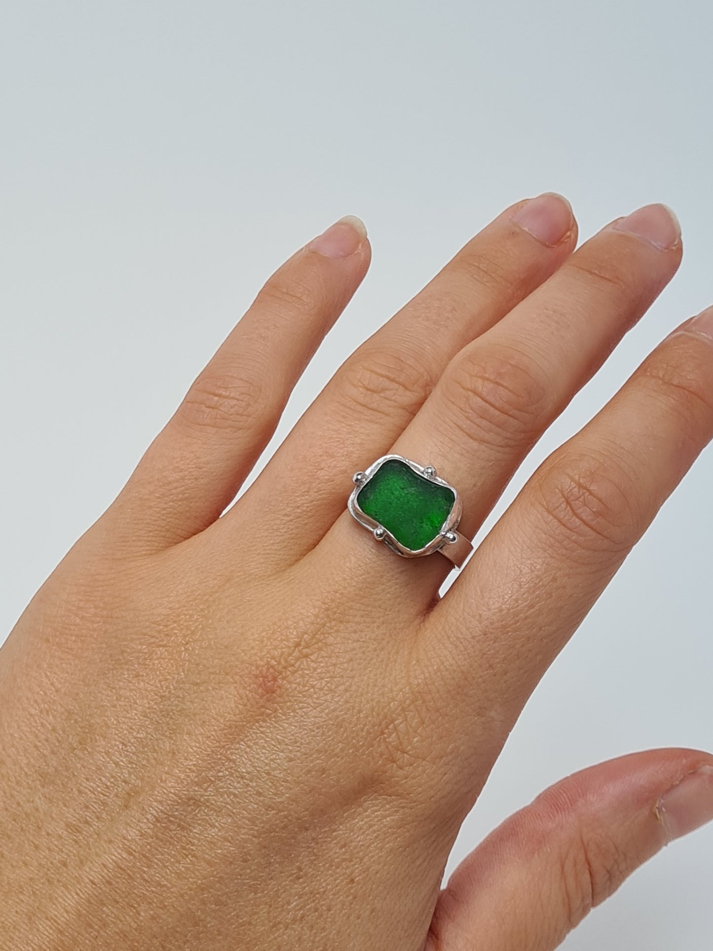 This vibrant green sea gem is nestled in a sterling silver bezel with subtle embellishments and set upon a thick band. Crafted with sustainability in mind this silver ring is handmade from 100% recycled silver.