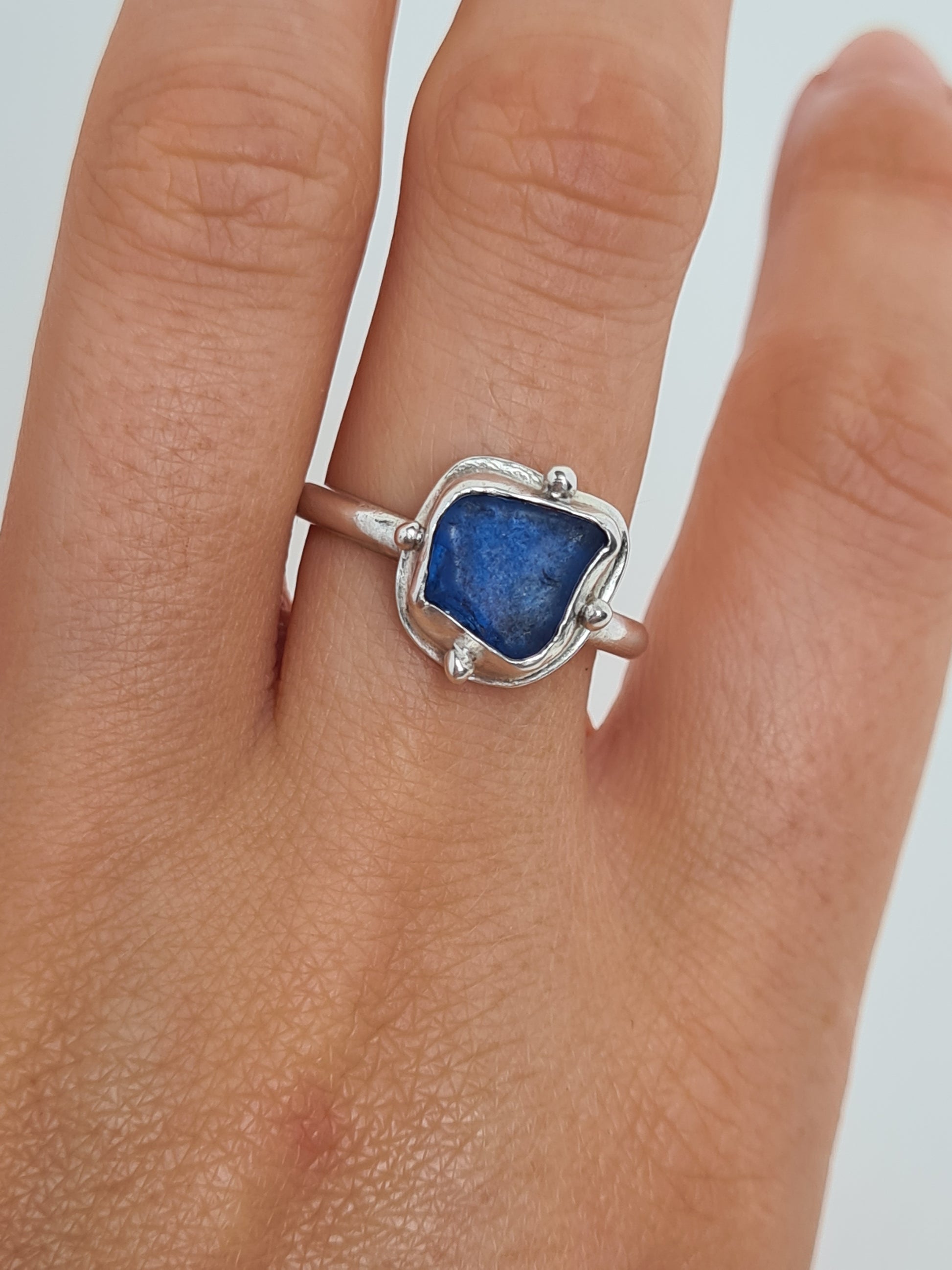 This vibrant royal blue sea gem is nestled in a sterling silver bezel with subtle embellishments and set upon an elegant D shaped band. Crafted with sustainability in mind this silver ring is handmade from 100% recycled silver.