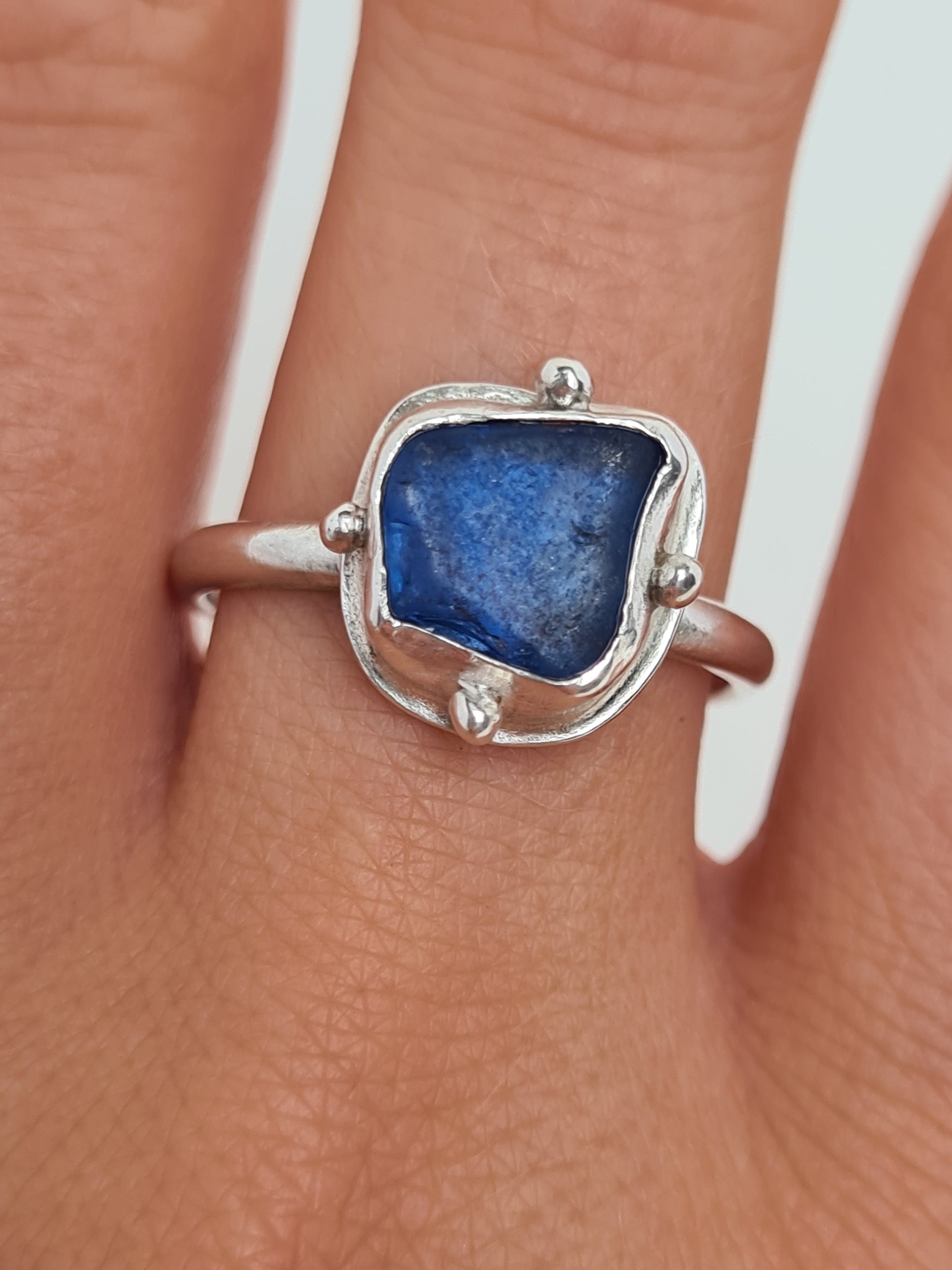 This vibrant royal blue sea gem is nestled in a sterling silver bezel with subtle embellishments and set upon an elegant D shaped band. Crafted with sustainability in mind this silver ring is handmade from 100% recycled silver.