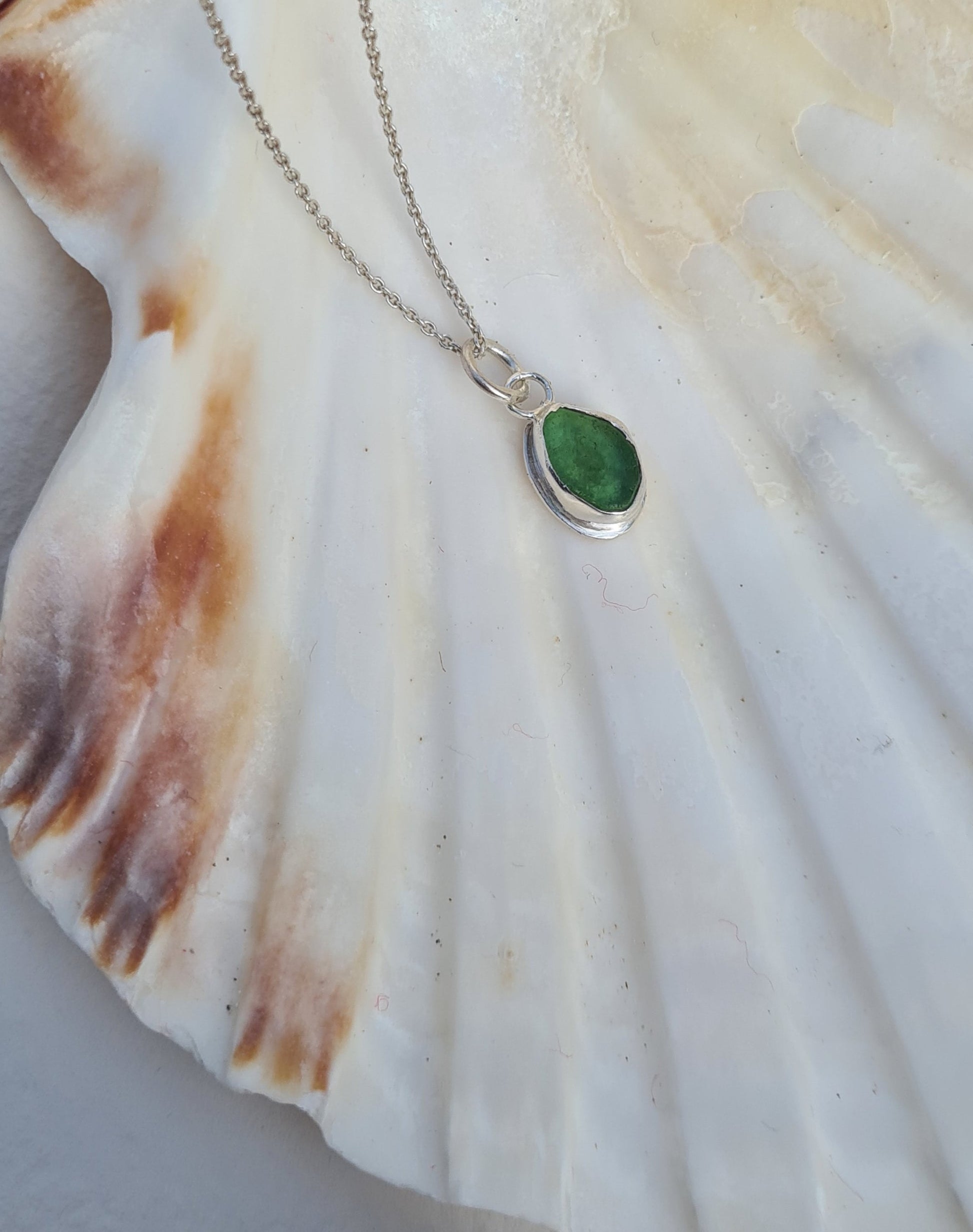 This bright little green piece of sea glass is nestled in a sterling silver bezel on a delicate silver cable chain. Handmade with sustainability in mind this silver necklace is made from 100% recycled silver.  This piece of sea glass was found in West Cork, Ireland. A fragment of our beloved Irish coastline forever preserved in silver. 